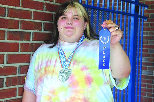 Interlachen’s Marissa McKibben shows off a couple of the awards she won as the girls weightlifting team’s unlimited division leader as a senior. (MARK BLUMENTHAL / Palatka Daily News)