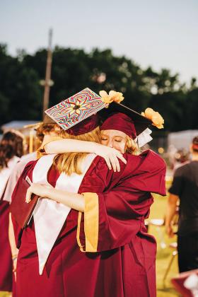 Two graduates share a teary-eyed hug after the Crescent City High ceremony.