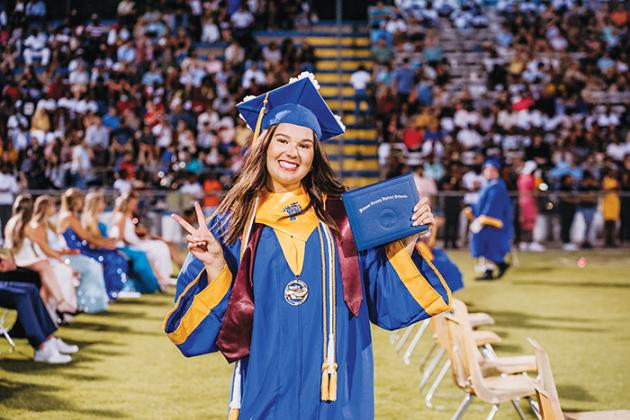 A Palatka High senior flashes the peace sign after receiving her diploma Friday night.