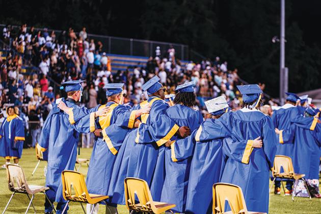 Graduates grasp each other during Palatka High’s commencement ceremony Friday night.