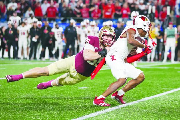 Florida State’s Brandon Fiske (left) grabs on to Louisville’s Jawhor Jordan during Saturday’s ACC Championship in Charlotte, N.C. (GREG OYSTER / Special to the Daily News)