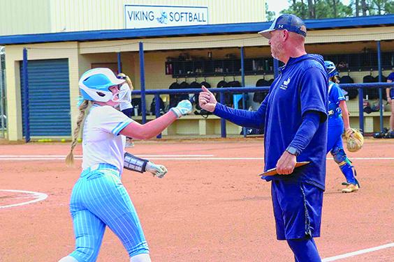  Vikings coach Joe Pound congratulates Princess Arredondo around third base after she hit a home run, one of four hit by the Vikings in the first game of the twinbill sweep. (RITA FULLERTON / Special to the Daily News)