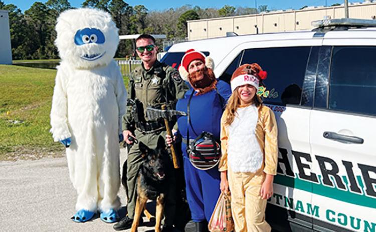 Putnam County Sheriff’s Office Deputy Kagen Butts and K-9 deputy Halo stand with K9s United members – BJ Johnson as the Abominable Snowman, Debbie Johnson as Yukon Cornelius and 10-year-old Emma Johnson as Rudolph – before receiving a gift on Christmas Eve, courtesy of K9s United.
