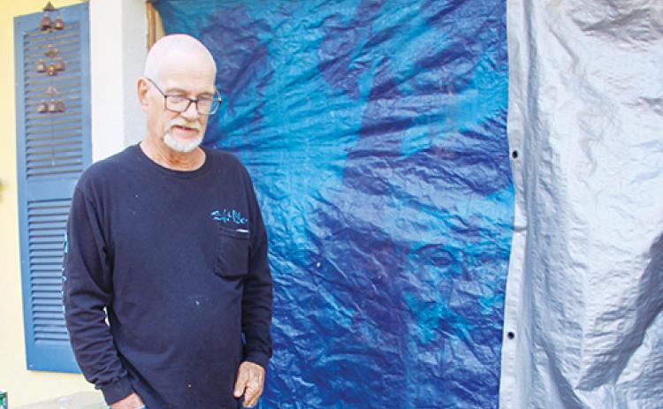 Satsuma resident David Newman stands in front of the tarp-covered hole in his sister’s home in Pomona Park.