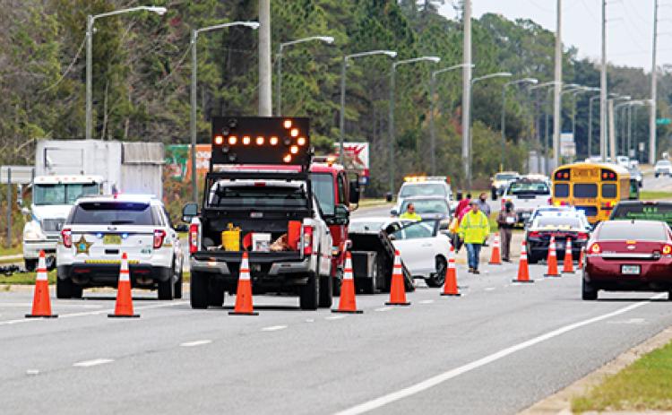 Cars move to the right lane heading eastbound on Crill Avenue as the Putnam County Sheriff’s Office, Florida Highway Patrol, and Johnson’s Towing and Recovery work on a crash involving a car and a school bus early Tuesday morning.