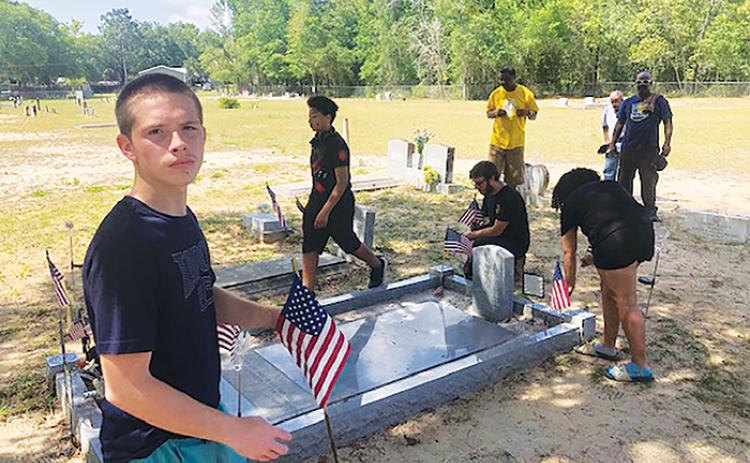 Interlachen Junior-Senior High School JROTC cadets clean the grave of Pfc. Robert H. Jenkins Jr. on Saturday.