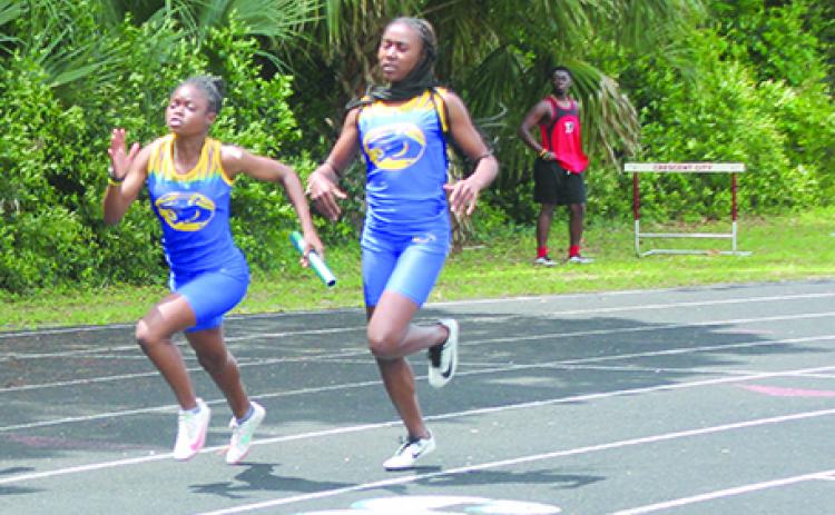 Palatka’s Ymira Passmore (left) receives the handoff from Khalia Wright during the 4x100 relay at the April 21 District 5-2A championship at Palatka Junior-Senior High. The relay team won the race and are competing in Thursday’s state championship. (MARK BLUMENTHAL / Palatka Daily News)