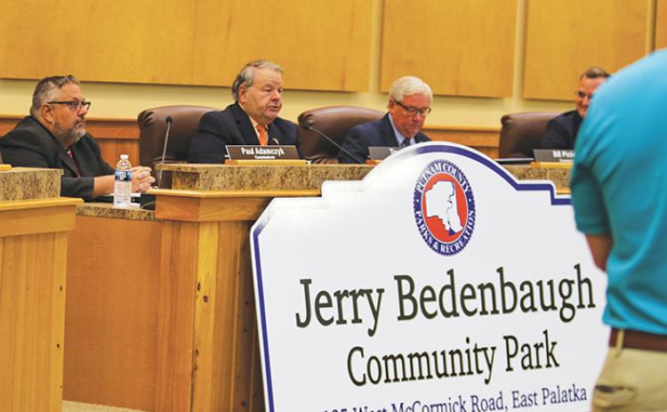 County Commissioner Terry Turner, second from left, talks about former businessman and retired Florida Highway Patrol trooper Jerry Bedenbaugh after unveiling a new community park sign Tuesday.