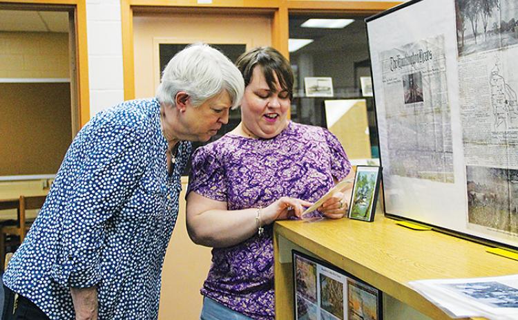 Cherie Register, left, and Rachel Cavanaugh look at historical photos from the Margary Neal Jones Nelson Archives, named for Register’s mother, in Crescent City.