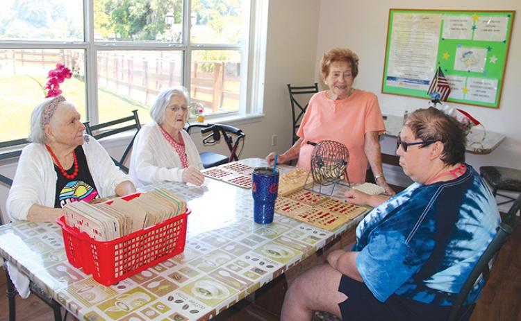 Helen Harrell enjoys her time visiting with residents of the Crescent Lake House where she calls bingo for them twice a week. Seated from left are Carolyn DeCamp, Mary Smith and Michelle White. 