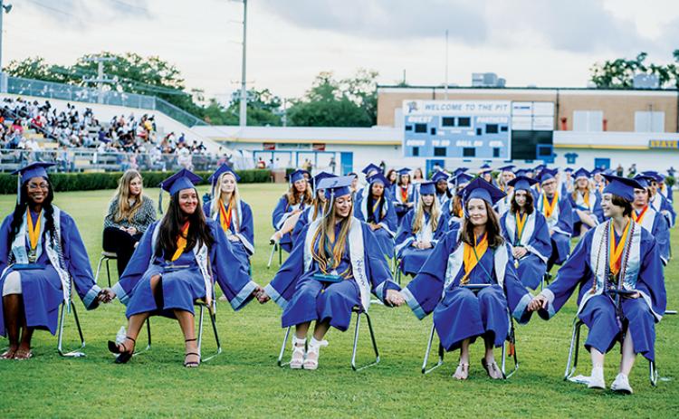 Q.I. Roberts Junior-Senior High School graduates hold hands during their commencement ceremony Saturday evening in Palatka.