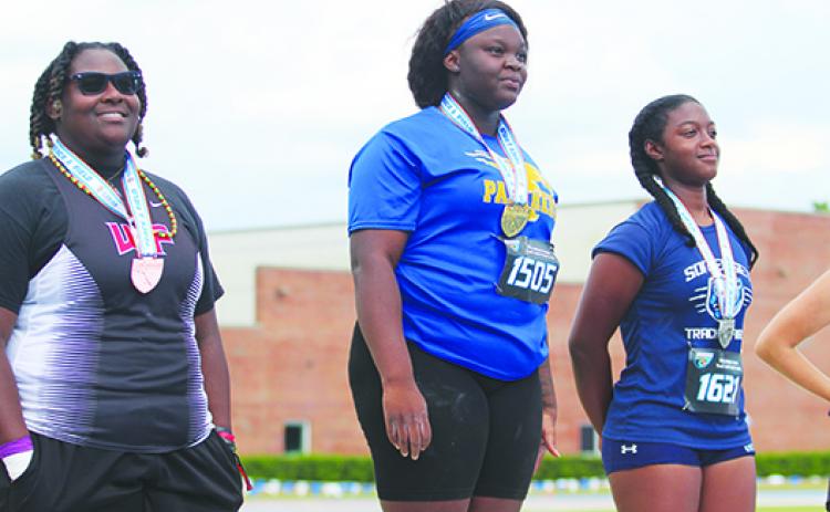 Palatka’s Torryence Poole (left) smiles after receiving her gold medal for winning the FHSAA 2A shot put championship for the second straight year on May 12 at the University of Florida. (MARK BLUMENTHAL / Palatka Daily News)