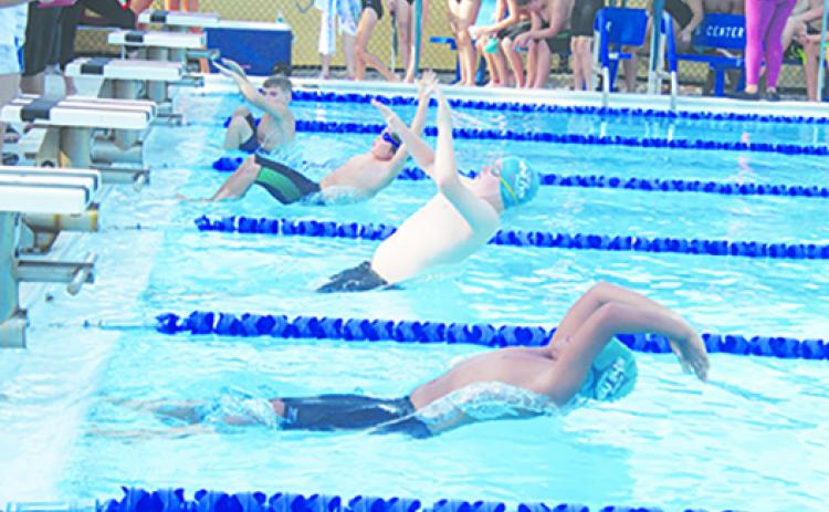 Putnam Sharks swimmers Jackson Young (center) and Mikah Gilyard dive into the pool at the start of the 9-10-year-old division 50-yard backstroke on Saturday at the Putnam Aquatic Center. Young would win the event. (MARK BLUMENTHAL / Palatka Daily News)