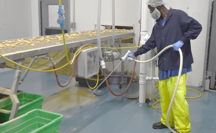Frank Taylor, a repeat offender who Comarco Products hired through a partnership with the Putnam County Sheriff's Office, sprays debris off the Palatka factory's floor last week. Taylor said the job program has helped him escape a cycle of crime.