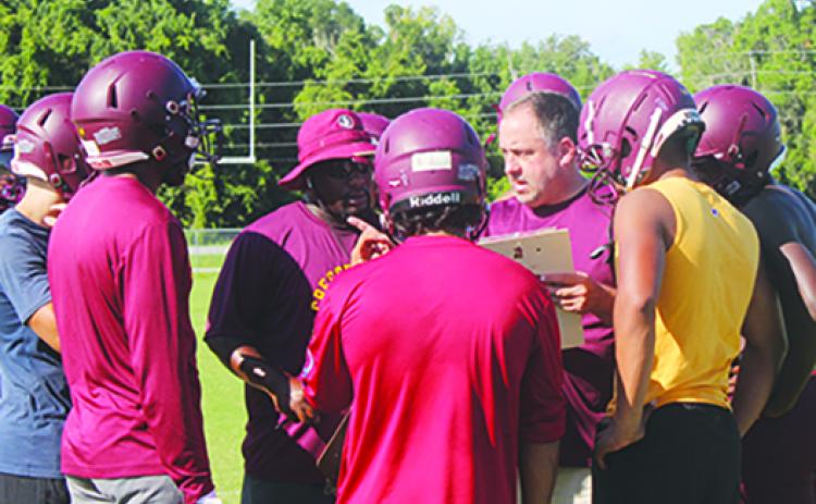 Crescent City head coach Sean Delaney (center, right), starting his third year in charge of the Raiders, goes over special teams strategy during practice this week along with assistant Keenan Henry (center, left). Below, Palatka receiver Tay Valentine goes high to make a catch against Panthers defender Jaiden Ashley in a practice the first week of the season. (MARK BLUMENTHAL / Palatka Daily News)