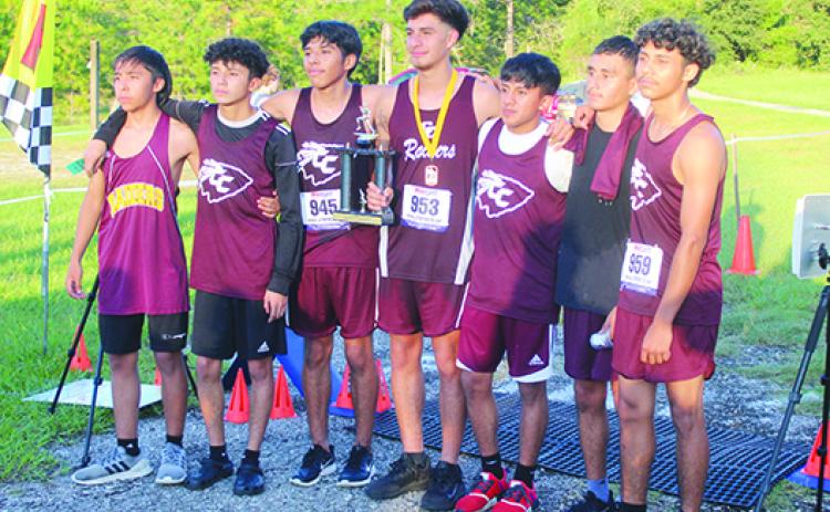 Crescent City’s boys team poses for pictures after winning the Dwayne Cox Invitational team title at West Putnam Recreation Center on Tuesday. Below, Palatka's Ymira Passmore crosses the finish line in third place in the girls' race. (MARK BLUMENTHAL / Palatka Daily News)
