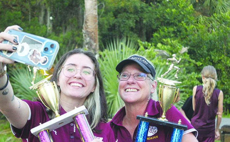 Crescent City assistant coach Alex Bittinger, left, takes a selfie with head cross country coach Jen Ewbank after the Raiders won both the boys and girls team championships at last week’s All-Putnam County championship at Ravine Gardens State Park. (MARK BLUMENTHAL / Palatka Daily News)