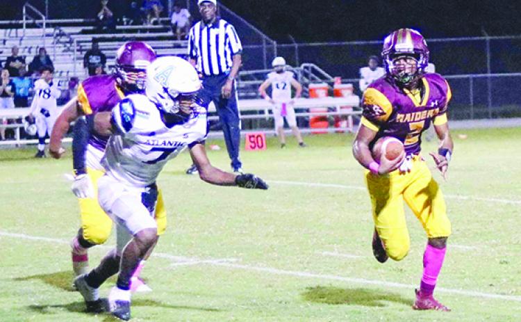 Crescent City quarterback Eric Jenkins Jr. scrambles to find space while being pursued by Port Orange Atlantic’s Preston Kuznof during Friday’s game. (RITA FULLERTON / Special to the Daily News)
