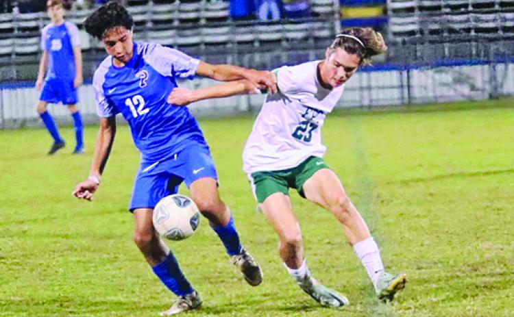 Palatka’s Isahu Aboytes (12) and Flagler-Palm Coast’s Aron Binkley for possession of the ball during the first half of last night’s game at Bennett-Cooper Field at Veterans Memorial Stadium. (RITA FULLERTON / Special to the Daily News)