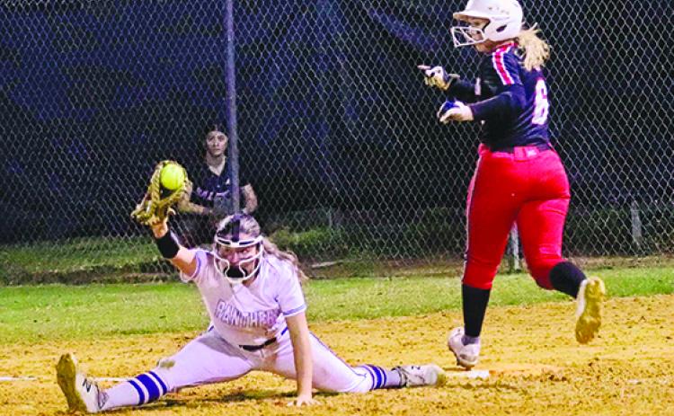 Palatka first baseman Zoey Clark does the splits to come up with the softball and record the out on Baldwin’s Chloe Gotto during Friday night’s game won by Baldwin, 9-0. (RITA FULLERTON / Special to the Daily News)