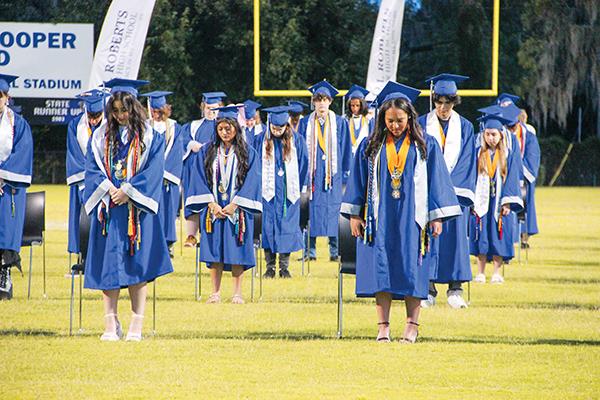 SARAH CAVACINI/Palatka Daily News – Q.I. Roberts Junior-Senior High School seniors bow their heads during the invocation at their commencement ceremony Saturday evening. 